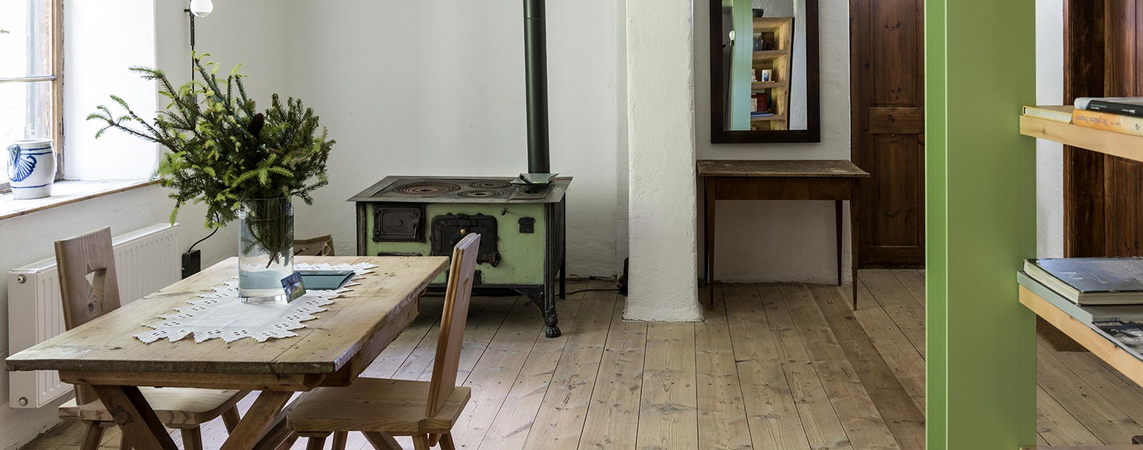Esstisch und traditioneller Holzherd eines Zimmers im Haus Settari des Briol in Dreikirchen