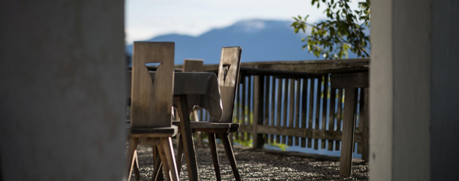 Tisch und Stühle aus Holz auf der Terrasse des Briol in Dreikirchen