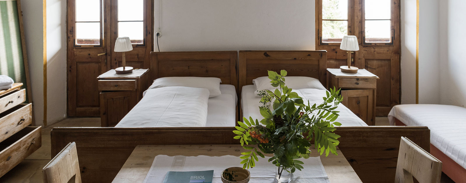 Tisch und Betten eines Zimmers des Hotels Briol in Barbian Dreikirchen